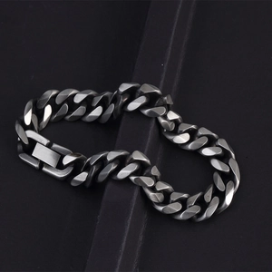 Macro detail of men's vintage stainless steel Cuban link bracelet with matte silver finish