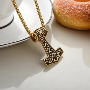 Detail of vintage gold Mjölnir pendant with intricate Norse relief and solid box chain