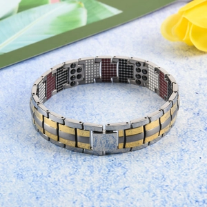Detalle de pulsera magnética de titanio para hombre con eslabones bicolor y piedras de energía