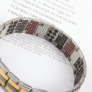 Detalle de pulsera magnética de titanio con piedras de energía y eslabones en plata y oro