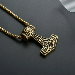 Detailed close-up of golden Viking Mjölnir pendant with intricate knotwork and square chain