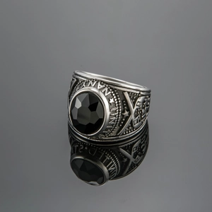 Macro detail of United States Navy ring with large black gemstone and side anchor relief