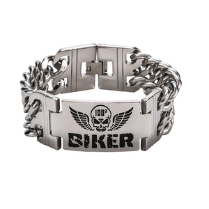 Close-up of a stainless steel biker bracelet with a skull and double wings engraving