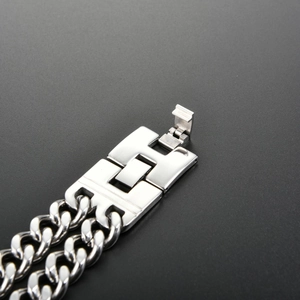 Detailed close-up of a silver biker skull bracelet with double cuban chain and folding clasp