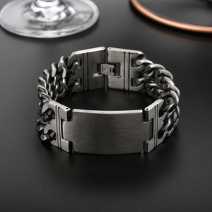 Detail of matte gunmetal stainless steel Cuban chain bracelet with rectangular metal plate