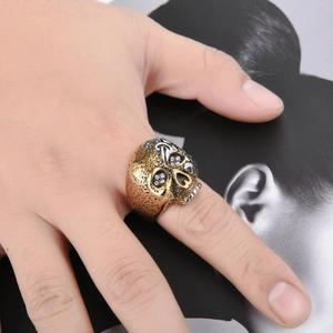 Anillo de calavera gótica para hombre en acero bicolor en la mano de un modelo