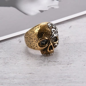 Detalle macro del anillo calavera retro con acabado dorado, relieve plata y piedras