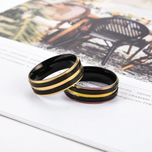 Details minimalistischer schwarzer Titanstahlringe mit Goldstreifen und Regenbogenrand