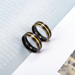 Details von gebürsteten schwarzen Edelstahlringen mit Goldstreifen und Regenbogenakzenten