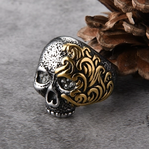 Detalle macro de anillo de calavera para hombre con relieve dorado y ojos brillantes