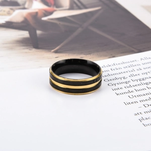 Nahaufnahme eines minimalistischen schwarzen Edelstahlrings für Herren mit goldenem Streifen