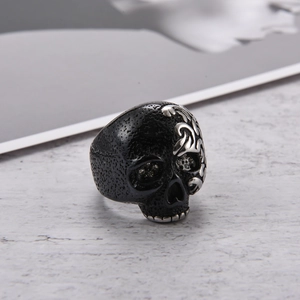 Vista macro de anillo calavera punk con textura negra mate y grabado plateado