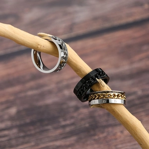 Detailed shot of Roman numeral rings with spinning chains on a rustic wooden stand