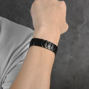 Herren Armband aus mattem schwarzen Titanstahl mit Magneten am Handgelenk präsentiert
