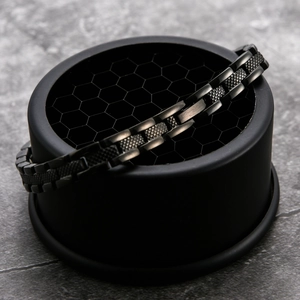 Detail eines matt schwarzen Titanstahl-Gliederarmbands mit kordierter Industriestruktur