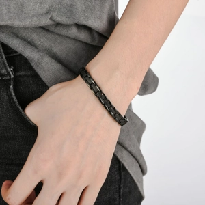 Minimalistisches schwarzes Edelstahlarmband für Herren mit Rändeltextur an einem Handgelenk