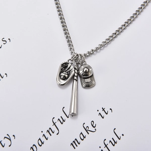 Vue macro du collier baseball avec pendentifs batte gant et casquette argentee