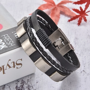 Détail du bracelet multicouche en cuir pour homme avec breloques argentées et fermoir aimanté