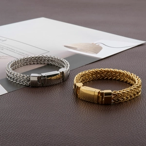 Dettaglio di bracciali a catena intrecciata in acciaio inox con chiusura magnetica su pelle