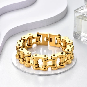 Detailed view of a gold stainless steel motorcycle chain bracelet on a white display
