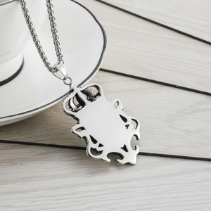 Détail d'un pendentif bouclier vintage avec couronne sur une chaîne tressée argent