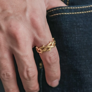 Gros plan sur une bague épine dorée polie portée à la main pour un style street fashion