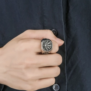Dettaglio di anello vintage in argento con foglia di cannabis su mano maschile