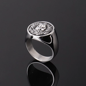 Polished stainless steel lion head ring with punk skull relief on a black background