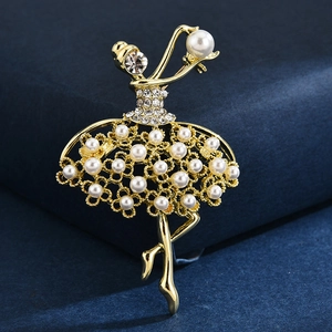 Eleganter goldener Ballett-Brosche mit weißen Perlen und Kristallen auf blauem Samt