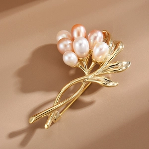 Elegante Blumenbrosche aus Gold mit sechs rosa Süßwasserperlen auf neutralem Grund