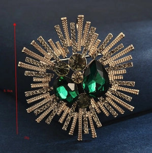 Detailed close-up showing a 6cm vintage emerald crystal brooch on blue velvet