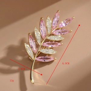 Vue macro de la broche branche d'olivier avec gemmes roses et strass blancs, 6x2,9 cm