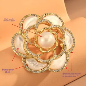 Détail de la broche camélia avec pétales en nacre naturelle et zircons blancs