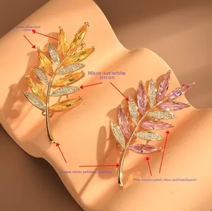 Vue détaillée de broches branche d'olivier avec zircons jaunes et roses en cuivre poli