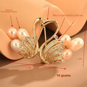 Détail de l'élégante broche double cygne avec perles d'eau douce et pierres de zircon