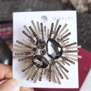 Elegant silver sunburst brooch with dark grey crystals and rhinestones for women
