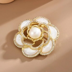 Élégante broche camélia en nacre avec perle et cristaux sur monture dorée