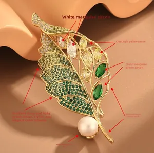 Détail de la broche feuille avec zircons verts, placage à l'or et perle blanche ronde