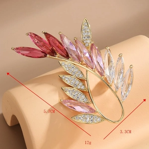Detail view of crystal olive branch brooch with 5.7cm height and 3.3cm width dimensions