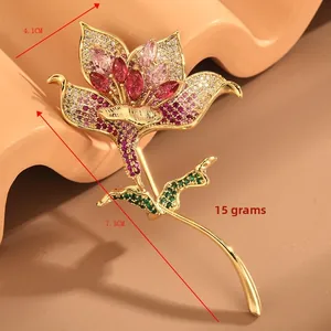 Détail macro d'une broche lys avec zircons roses et tige en cristal vert, 4,1x7,3cm