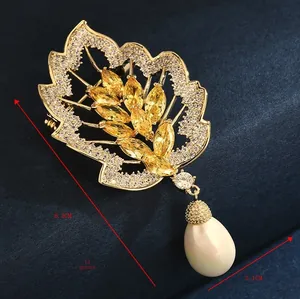 Macro shot of leaf brooch with yellow marquise gems and drop pearl, 6.3cm x 3.1cm