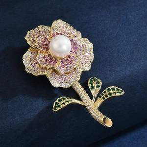 Luxurious flower brooch with white pearl, pink and white cubic zirconia on golden base