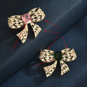 Detailed macro view of bow brooches with pink and green stones and sparkling white zircons
