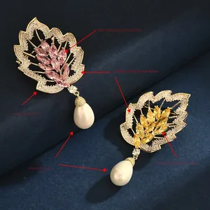 Detail of copper leaf brooch with pink zircon and teardrop pearl on blue velvet