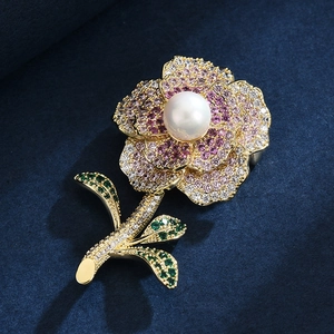 Elegant floral brooch with pink zircon petals, white pearl center and gold plated stem