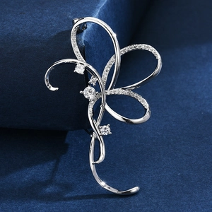 Elegant silver bow brooch with cubic zirconia on premium deep blue velvet jewelry display