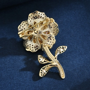 Back view of a gold flower brooch with micro-pave zircons and safety pin closure
