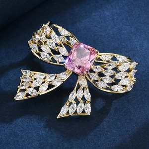 Bow brooch with pink rectangular crystal and white marquise zircons in gold setting