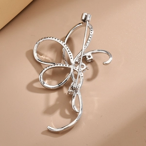 Elegant silver bow brooch with micro-pave zircons shown from a 45-degree back angle