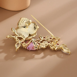 Broche fleur dorée élégante avec cristaux roses et pierres en goutte, vue de l'arrière
